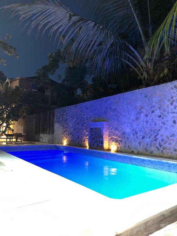a swimming pool at night with lights at CASINHA FLOR, vila florescer, centro histórico! in Piranhas