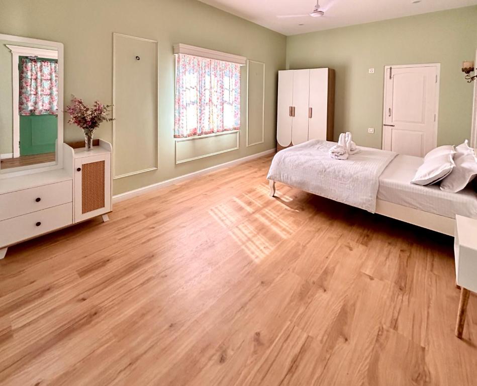 una camera da letto con due letti e pavimento in legno di Deliana s Homestay a Dithur