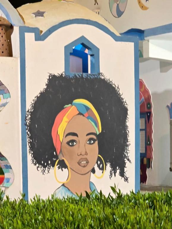 a mural of a woman with black hair at malindy KA nubian houseماليندى كا in Aswan