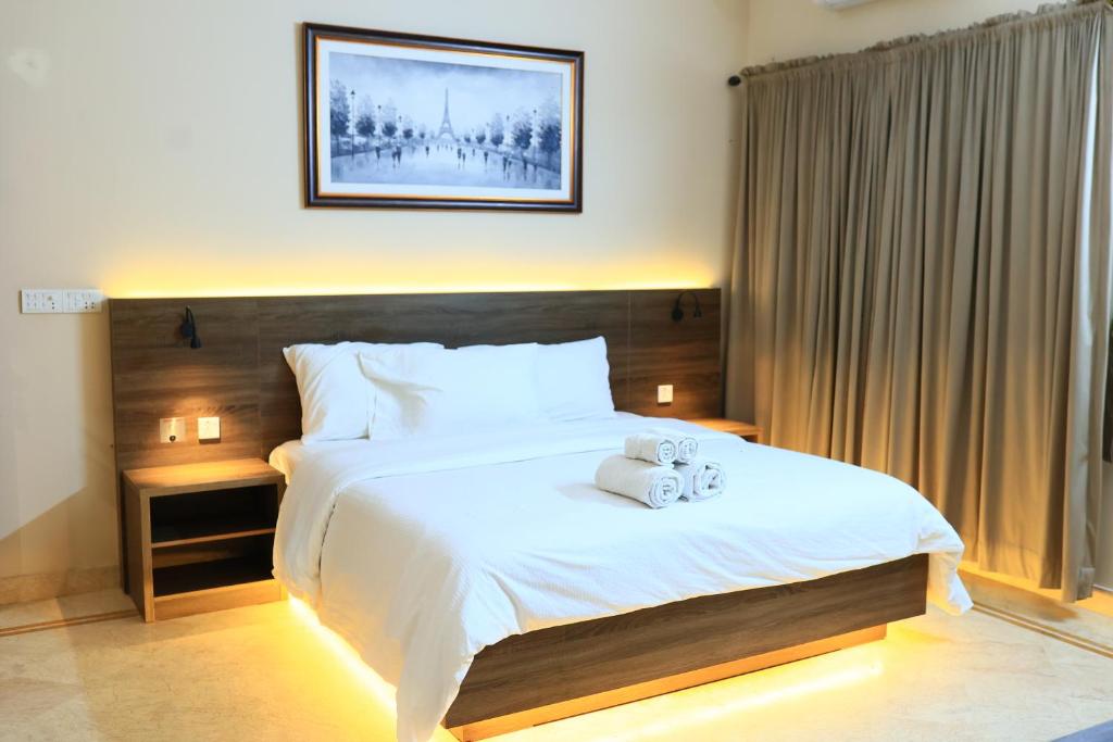 a bedroom with a bed with two towels on it at Majestic BnB in Karachi