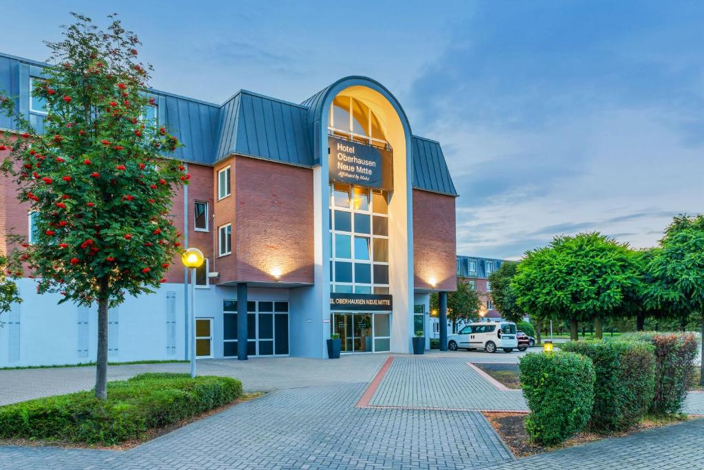 ein Gebäude mit einem Baum davor in der Unterkunft Hotel Oberhausen Neue Mitte affiliated by Meliá in Oberhausen