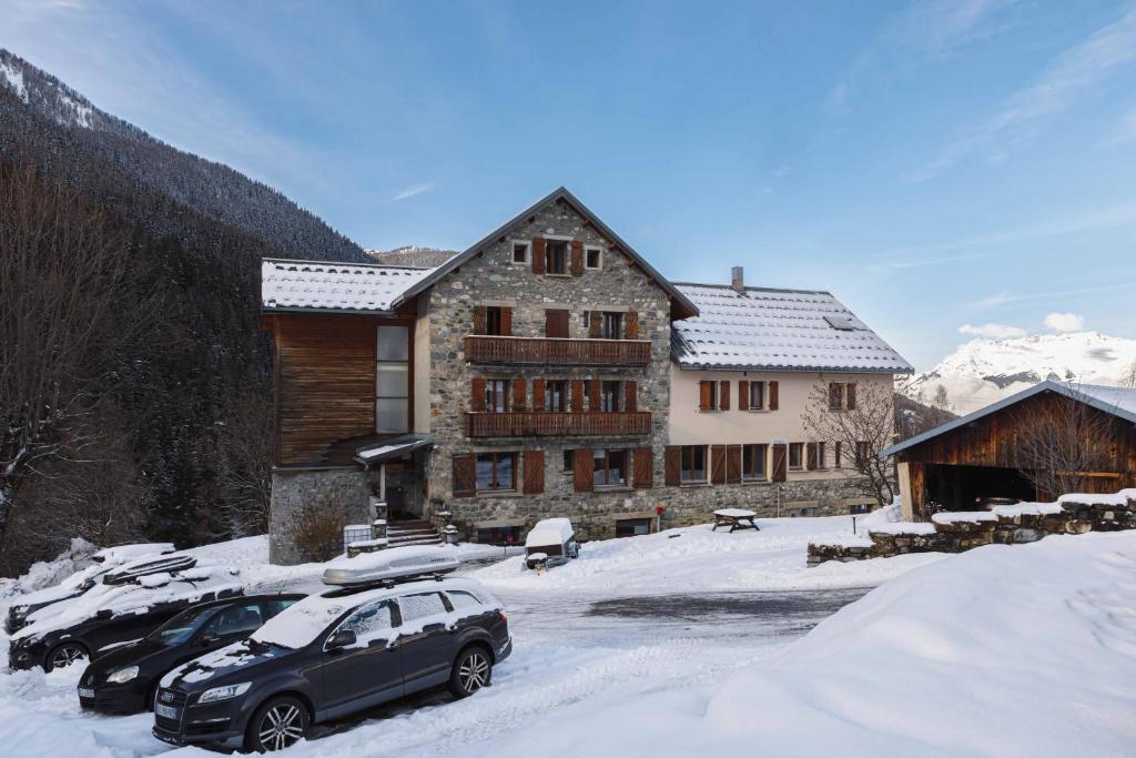 a building with two cars parked in the snow at Hotel Chalet du Bon Air in Peisey-Nancroix