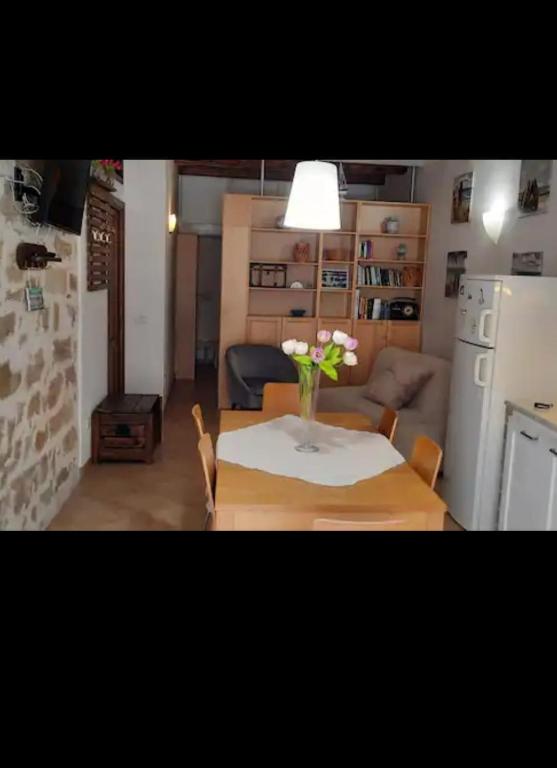 a living room with a table with a vase of flowers on it at Civico 67 in Alghero