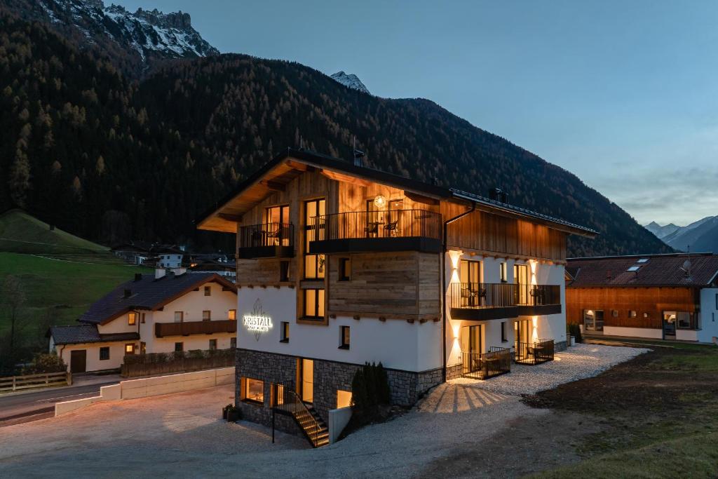 a large building with a mountain in the background at Kristall Apartments in Neustift im Stubaital