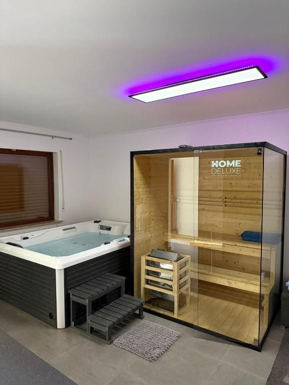 a jacuzzi tub in a room with a purple light at Ferienwohnung mit Pool und Sauna - Medebach in Medebach