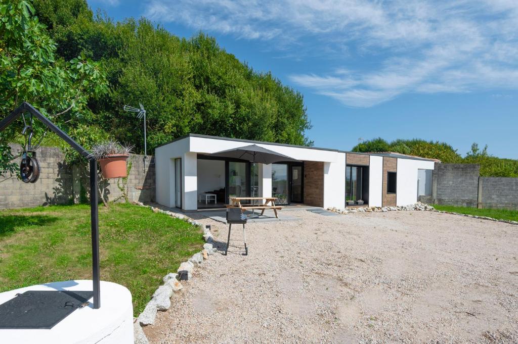 a house with a table and an umbrella at O REMANSO do CORGO in Oleiros