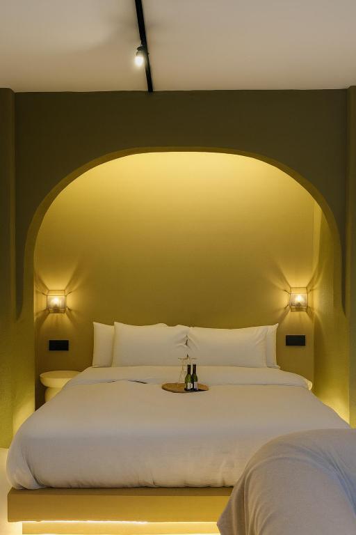 a bedroom with a large white bed with two lights at Marabou Unique Stay in Thessaloniki