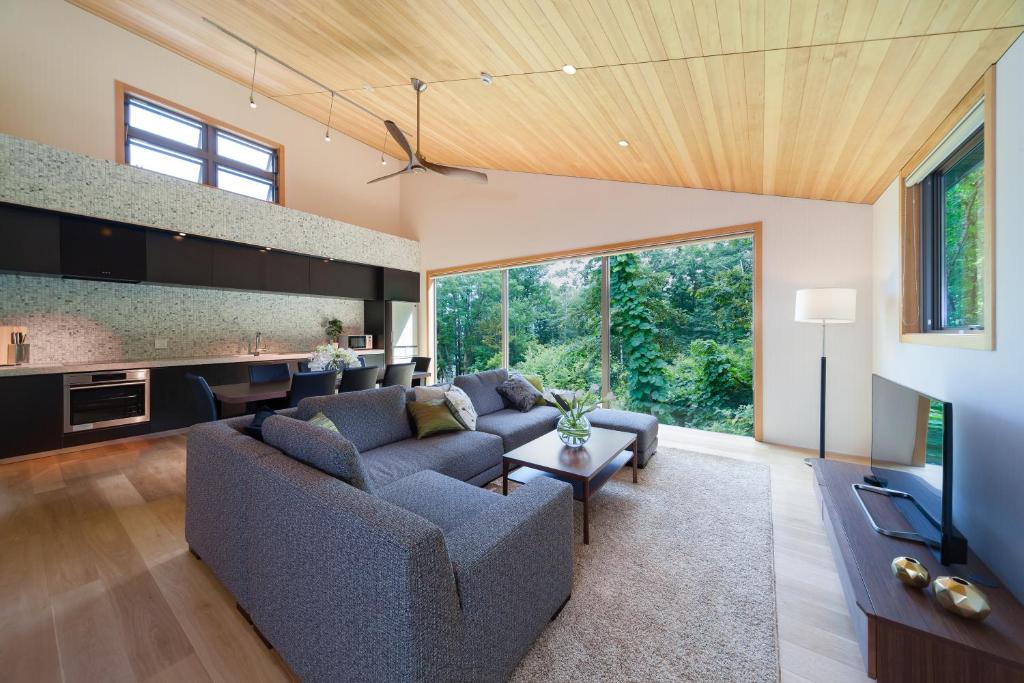 a living room with a couch and a table at SOLAR CHALETS by Hakuba Hotel Group in Hakuba