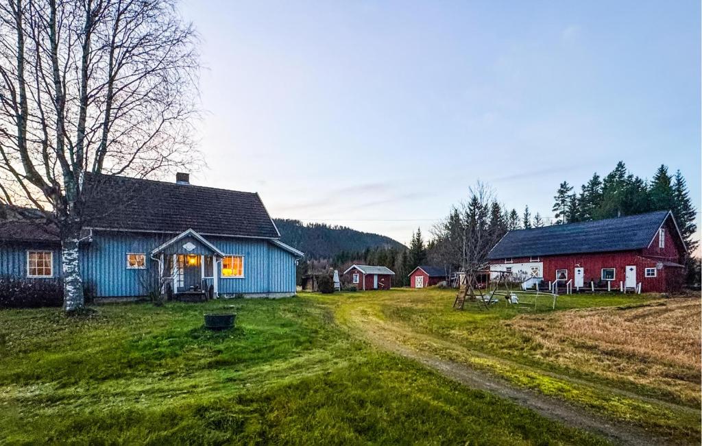 una granja con una casa azul y edificios rojos en Nice Home In Braskereidfoss With Wifi, en Skårå