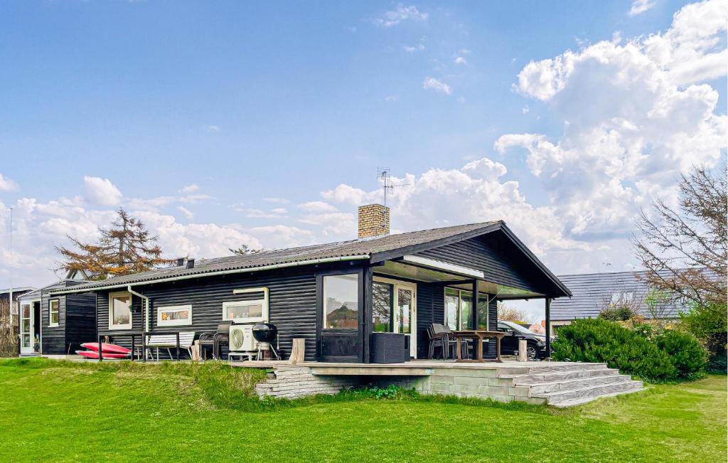 a small black house with a green lawn at Gorgeous Home In Assens With Wifi in Assens