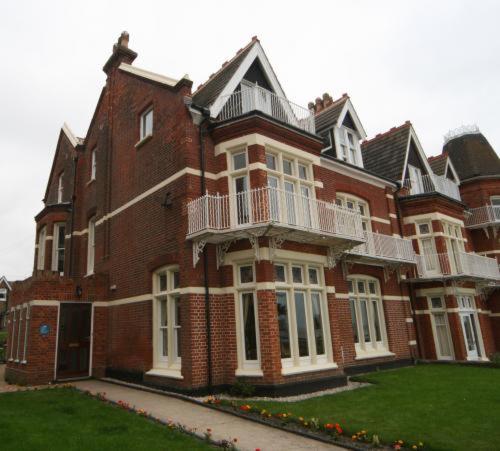 a large red brick building with a balcony at Britten House in Lowestoft