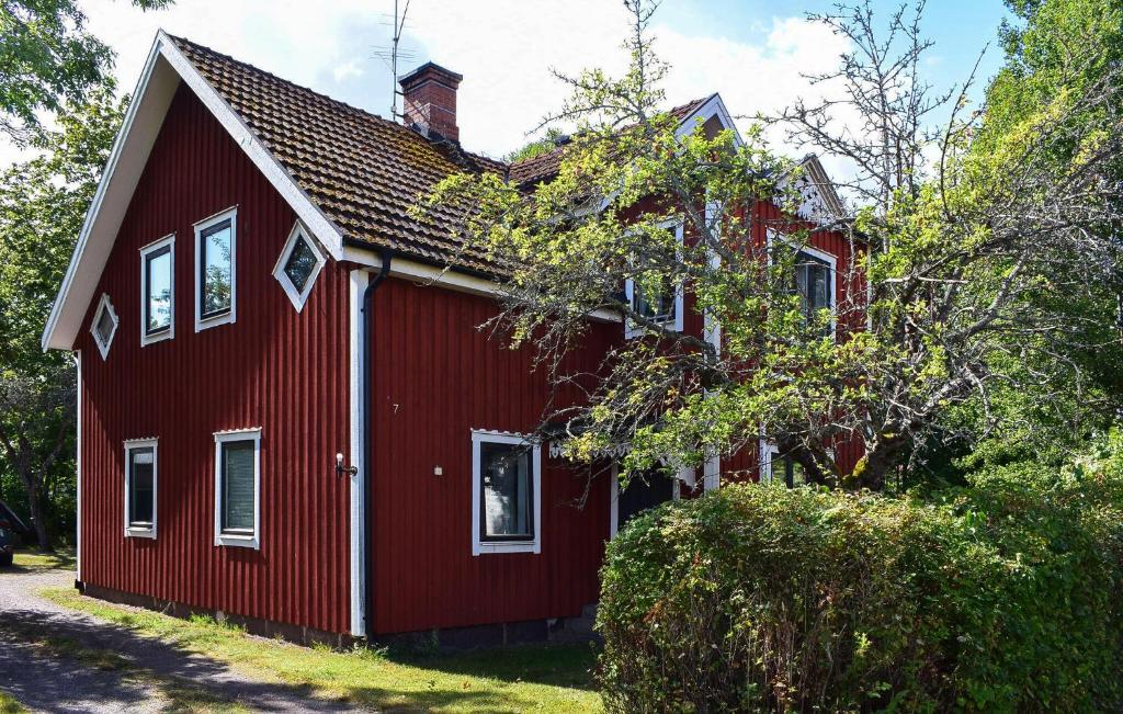 a red house with white windows on the side of it at 1 Bedroom Amazing Apartment In Hultsfred in Hultsfred