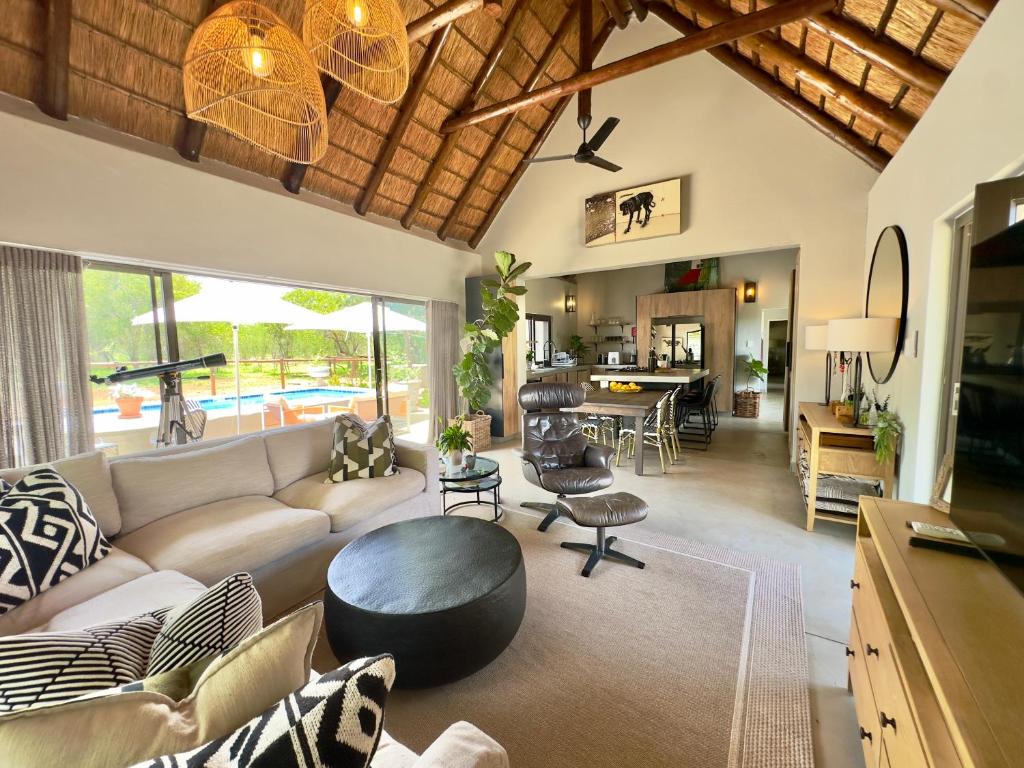 a living room with a couch and a table at Wildlife Estate Villa - Pool - Boma - Bushlife in Hoedspruit
