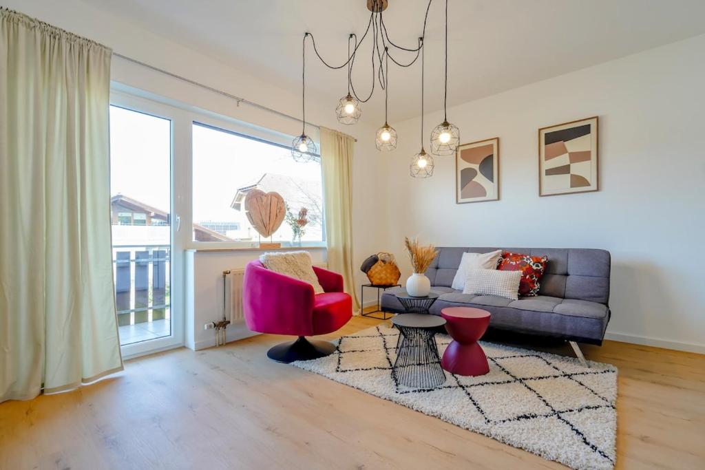 una sala de estar con un sofá y una silla en ERB03 Apartment Wohlgefühl, en Michelstadt