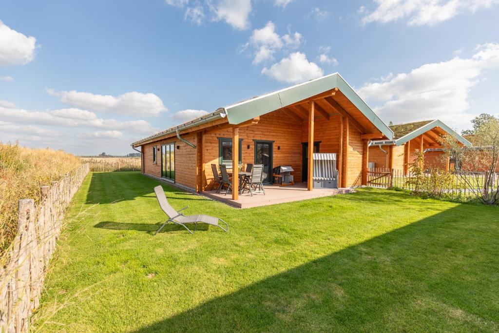 una casa in legno con un prato di fronte di Huus Katteker a Kating