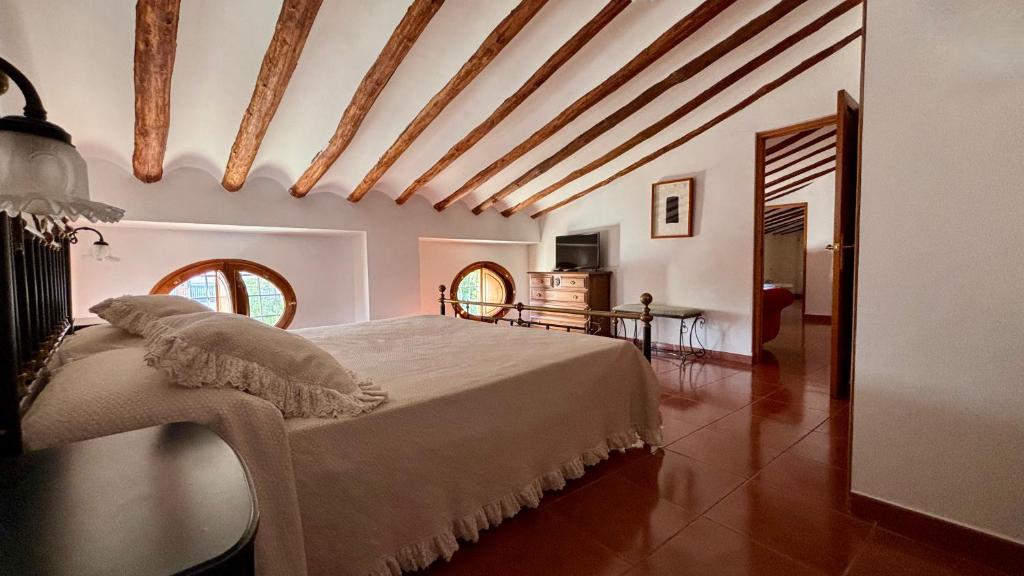 Un dormitorio con una cama grande y una mesa. en Hotel Casa de los Arcos, en Vélez Blanco