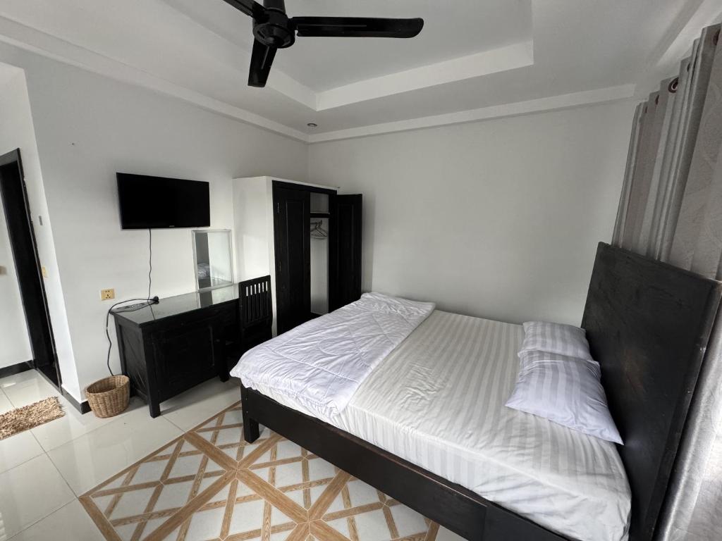 a bedroom with a bed and a flat screen tv at Villa de Sancho in Phumĭ Réach Born