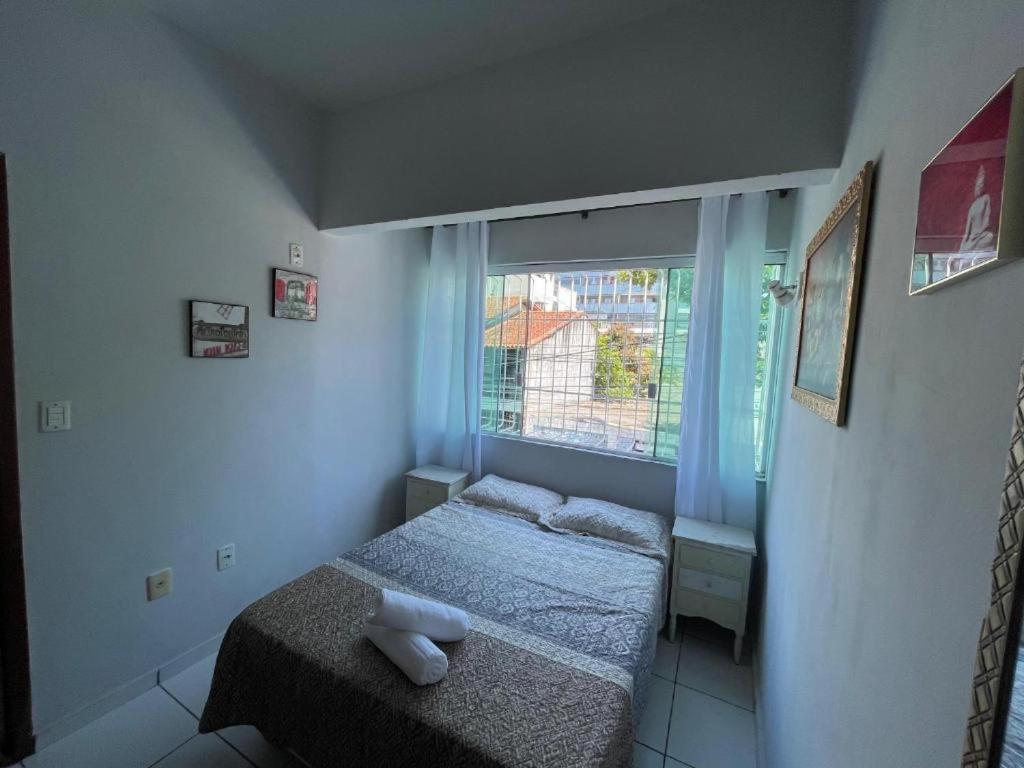 een kleine slaapkamer met een bed en een raam bij Pousada Maria Patricia l in Cabo Frio