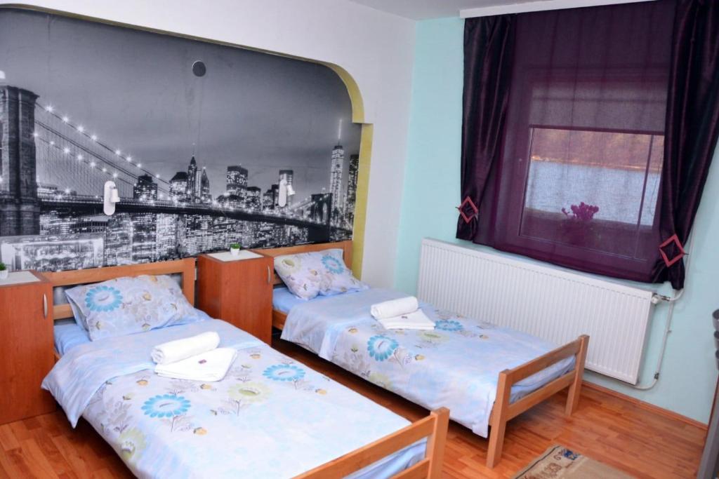 due letti in una stanza con un quadro sul muro di std- Na lepom plavom Dunavu a Kladušnica