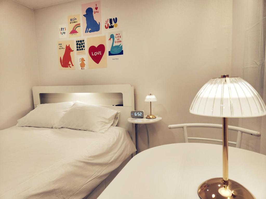 Cloud في سول: غرفة نوم بها سرير ومصباح على طاولة