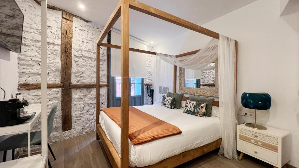 a bedroom with a four poster canopy bed at Pensión Lo Bilbao in Bilbao