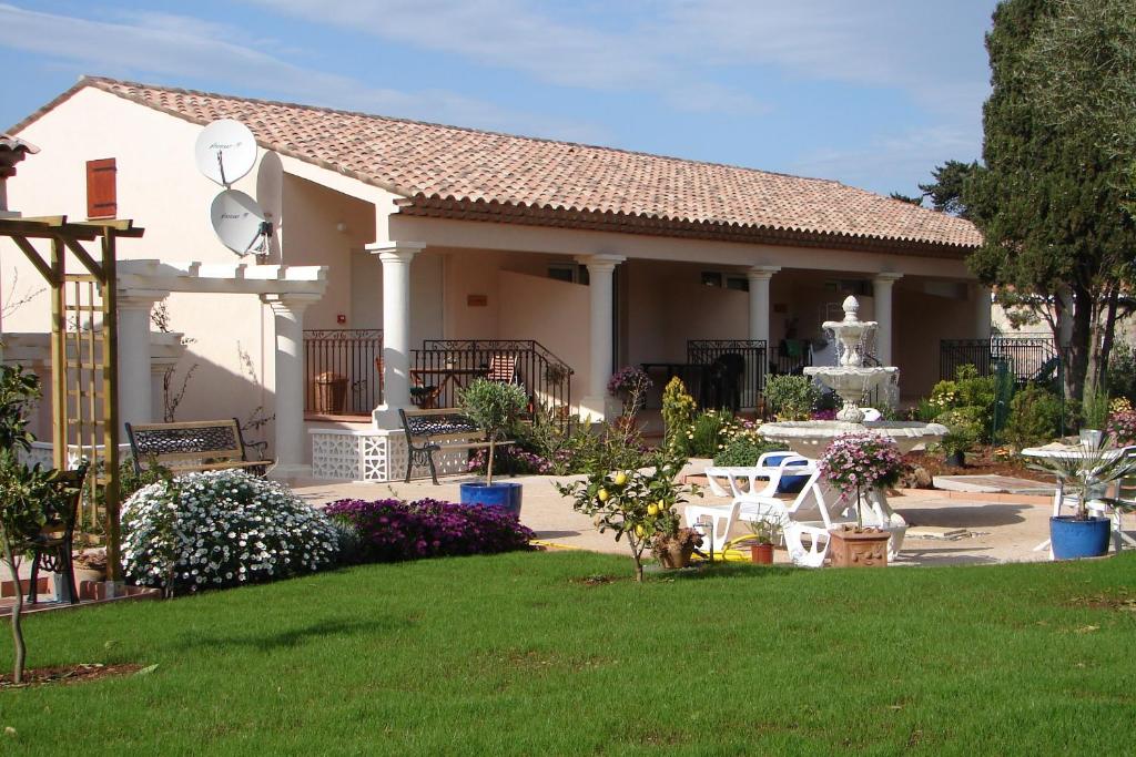 una casa blanca con una fuente en un patio en L'Orangeraie du Cap, en Antibes