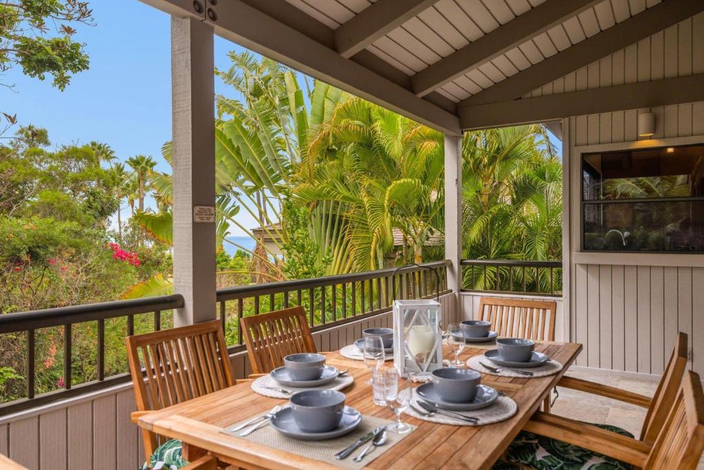 a wooden table on a porch with chairs and a table at Wailea Ekolu 1604 · WE 1604 Wailea 2BD Condo w AC Pool Near Beac in Kihei