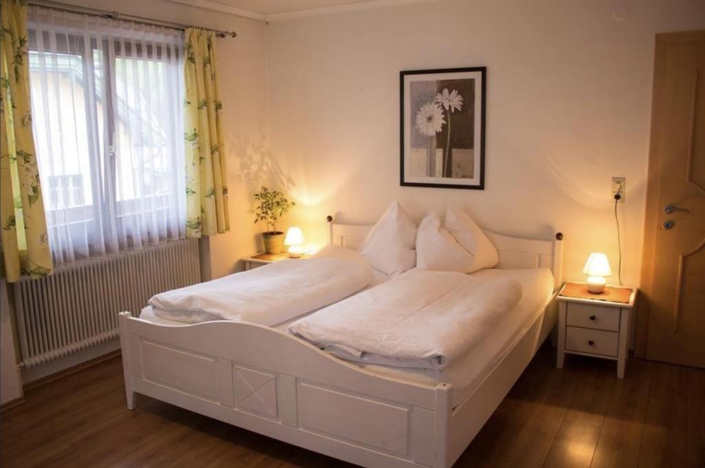 a white bed in a bedroom with a window at Pizzeria Prosser - Appartements in Dienten am Hochkönig