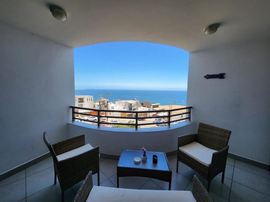 Un balcón con mesa y sillas y vista al mar. en Departamento 1 ambiente brisas del sur 2, en Iquique