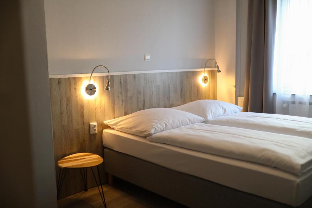a bed in a room with two lights on it at Hotel Allee 55 in Hannover