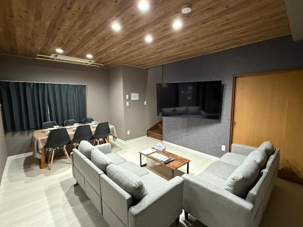 a living room with couches and a table and a television at Toko92 in Asahikawa