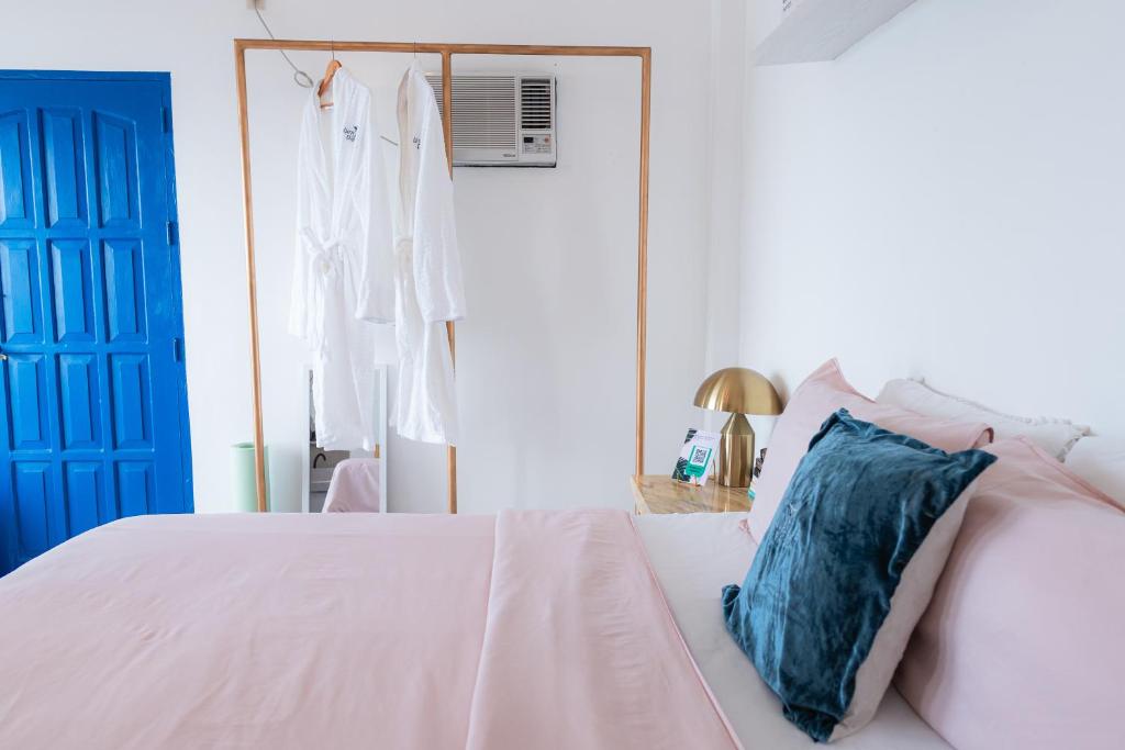 ein Schlafzimmer mit einem weißen Bett und einem blauen Kissen in der Unterkunft Bintana Sa Paraiso in Mambajao