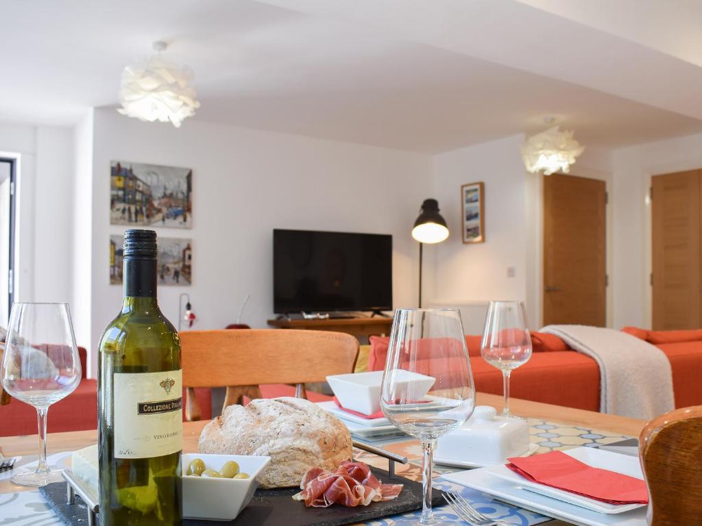 a bottle of wine sitting on a table with wine glasses at Potters Pad in Alnwick