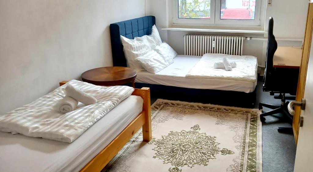 a room with two beds and a table and a window at Tripplezimmer mit Garten, Kicker und Grill in Berlin