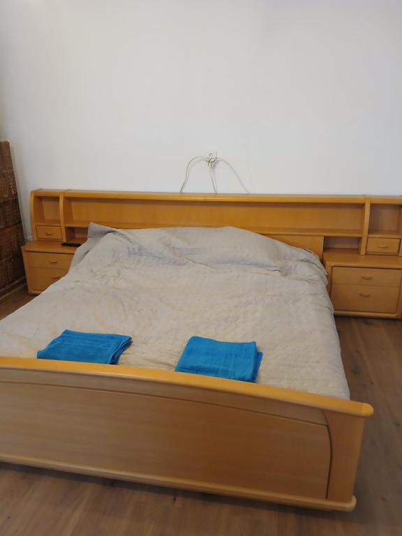 un letto in legno con due cuscini blu sopra di Casa Avocaților a Corabia