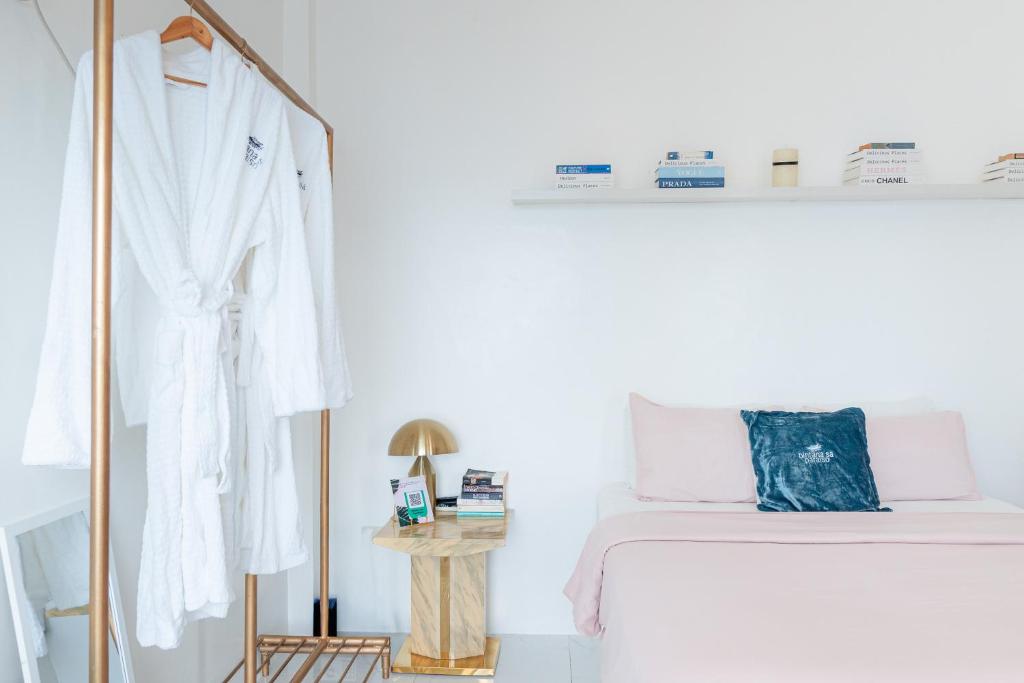 a white bedroom with a bed and a mirror at Bintana Sa Paraiso in Mambajao