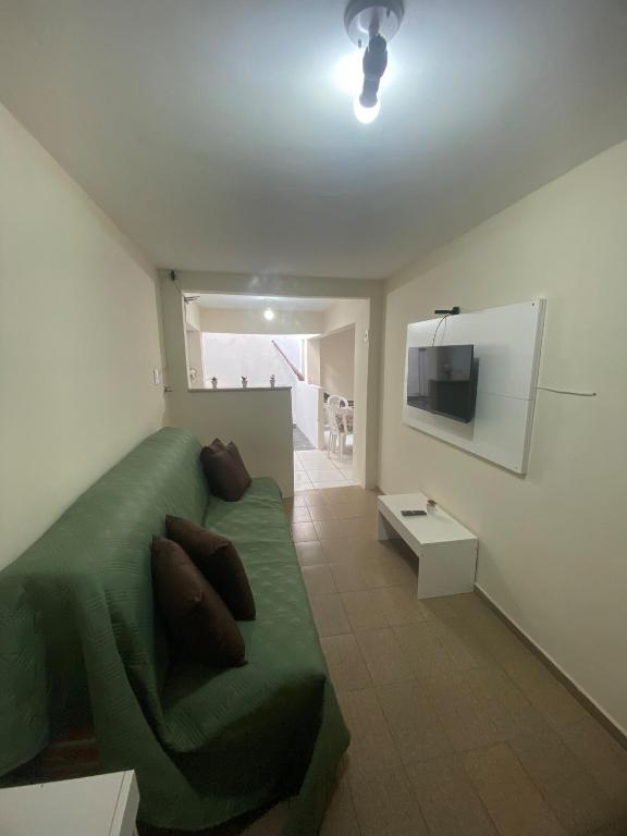 1 dormitorio con 1 cama verde y TV de pantalla plana en Ao lado do Hospital Calixto excelente localização, en Itabuna