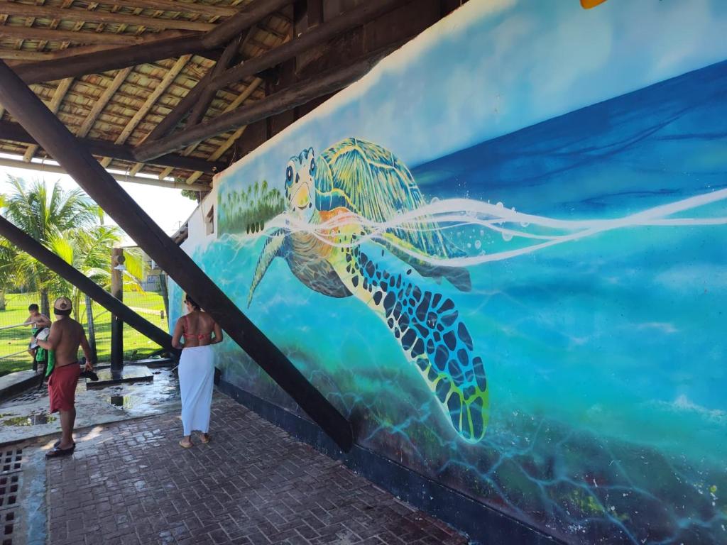 mural de una tortuga marina en una pared en Casas de Temporada Rua da Aurora em Praia do Forte Bahia, en Mata de Sao Joao