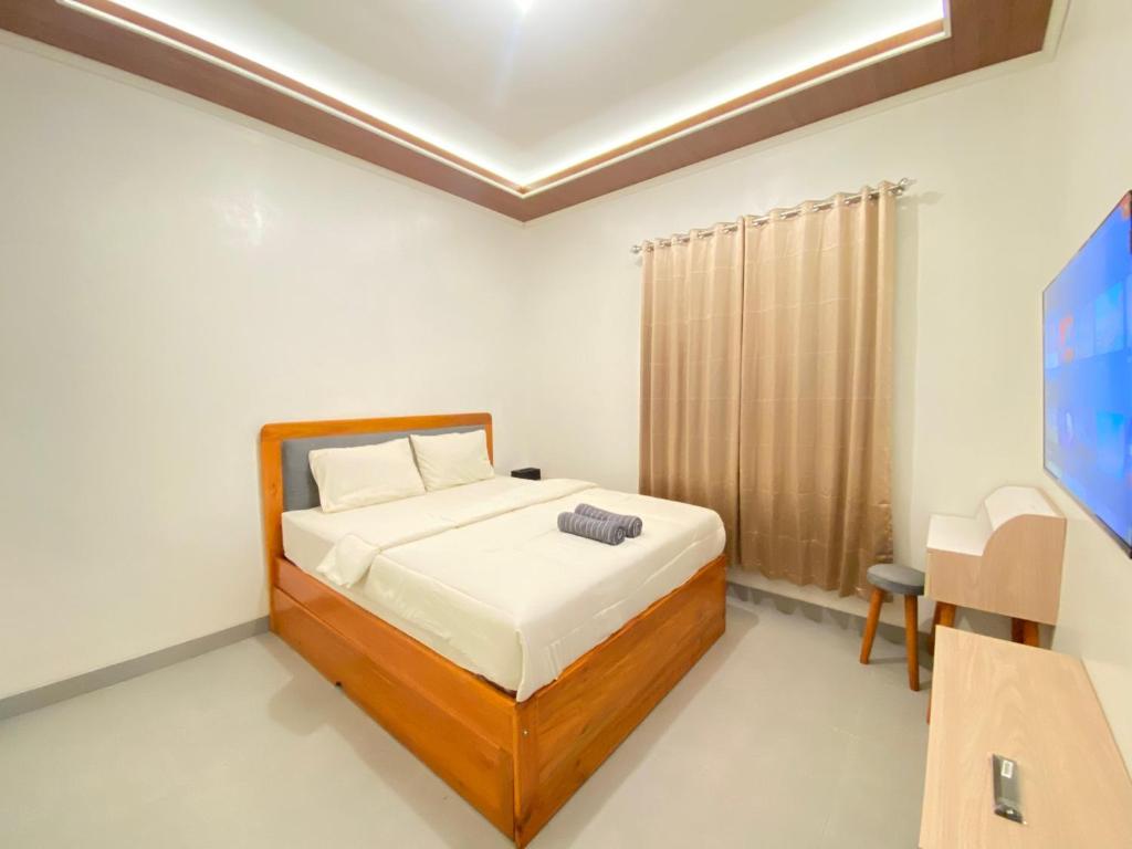 a bedroom with a bed and a television in it at Fatmara Villa Full House in Kejajar