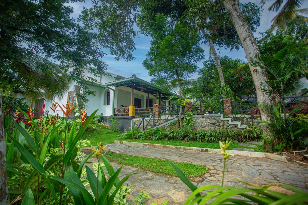 a house with a garden in front of it at Sleeper Wood Villa in Unawatuna