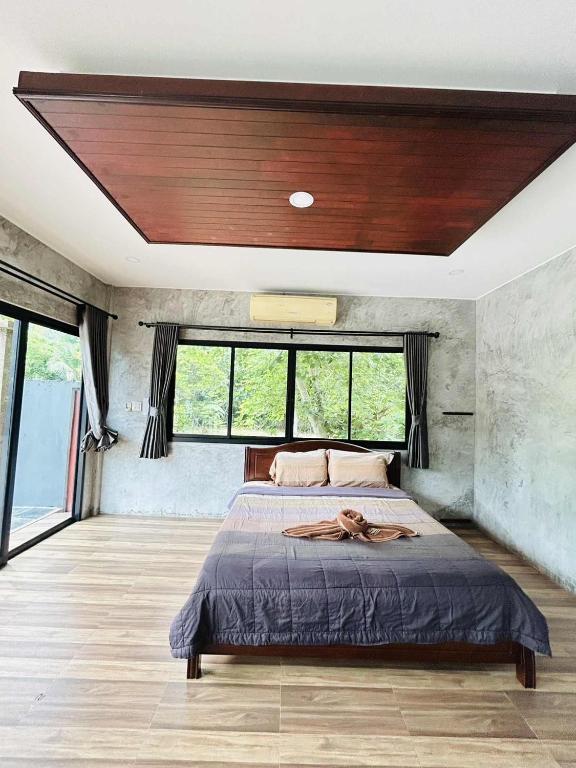 a bedroom with a large bed with a wooden ceiling at Share pool 1 room 2 bedroom in Ao Nang 