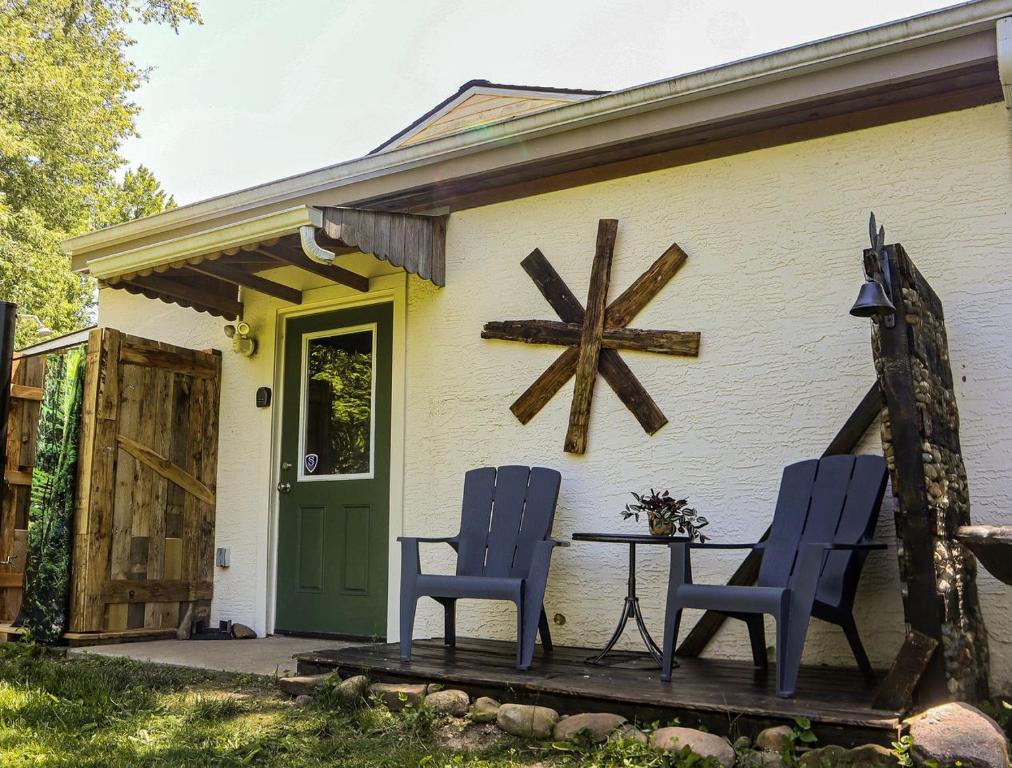 Cute Cozy Suite Rental Nestled on Beautiful Private Grounds for a Peaceful Getaway near Columbus, Ohio في Gould Park: منزل به كرسيان أزرقان وطاولة على الشرفة
