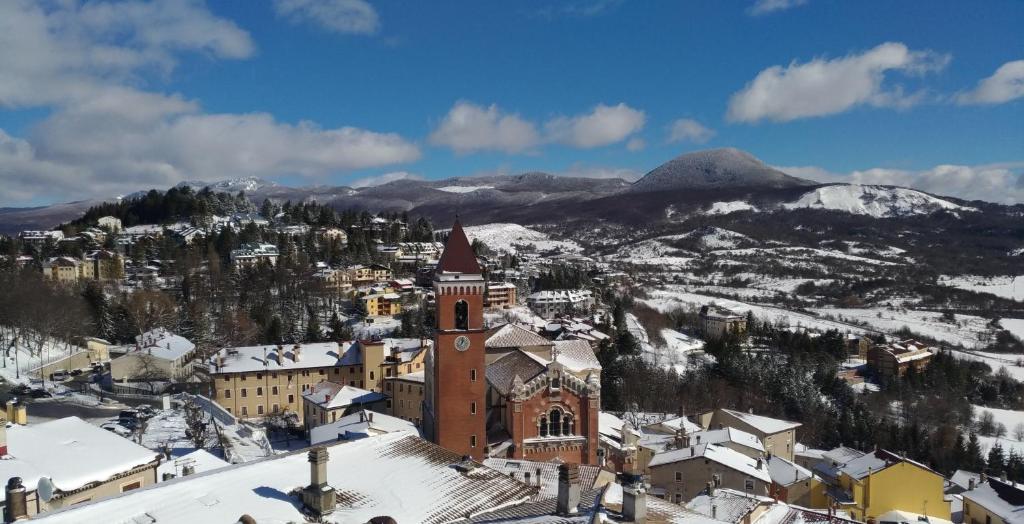 una città nella neve con una torre dell'orologio di La casetta di Rivisondoli a Rivisondoli