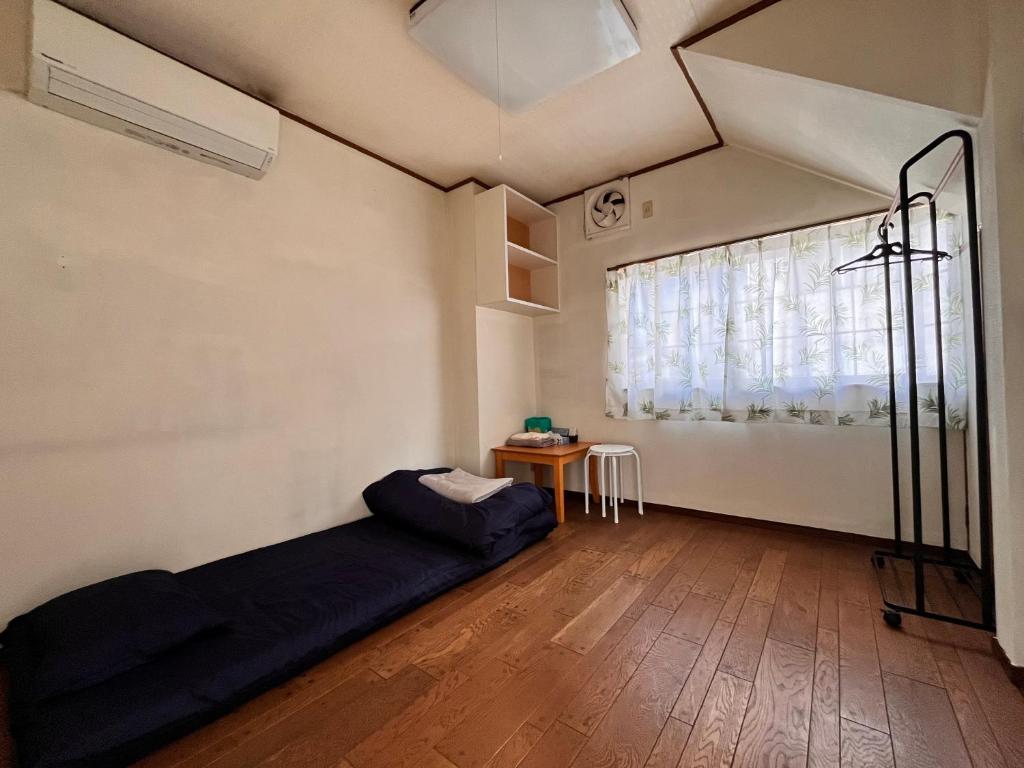 a bedroom with a bed in a room with a window at cozy guesthouse in Osaka