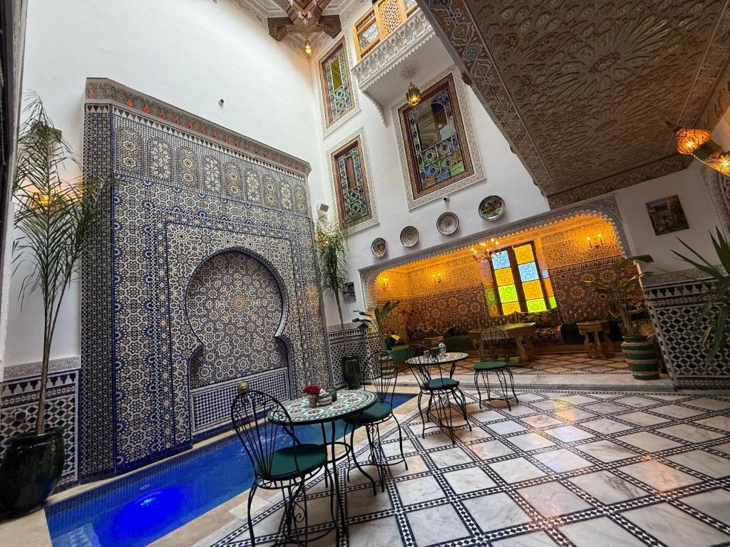 Una sala con billar y mesas en un edificio. en Riad Dar El bellar, en Fez