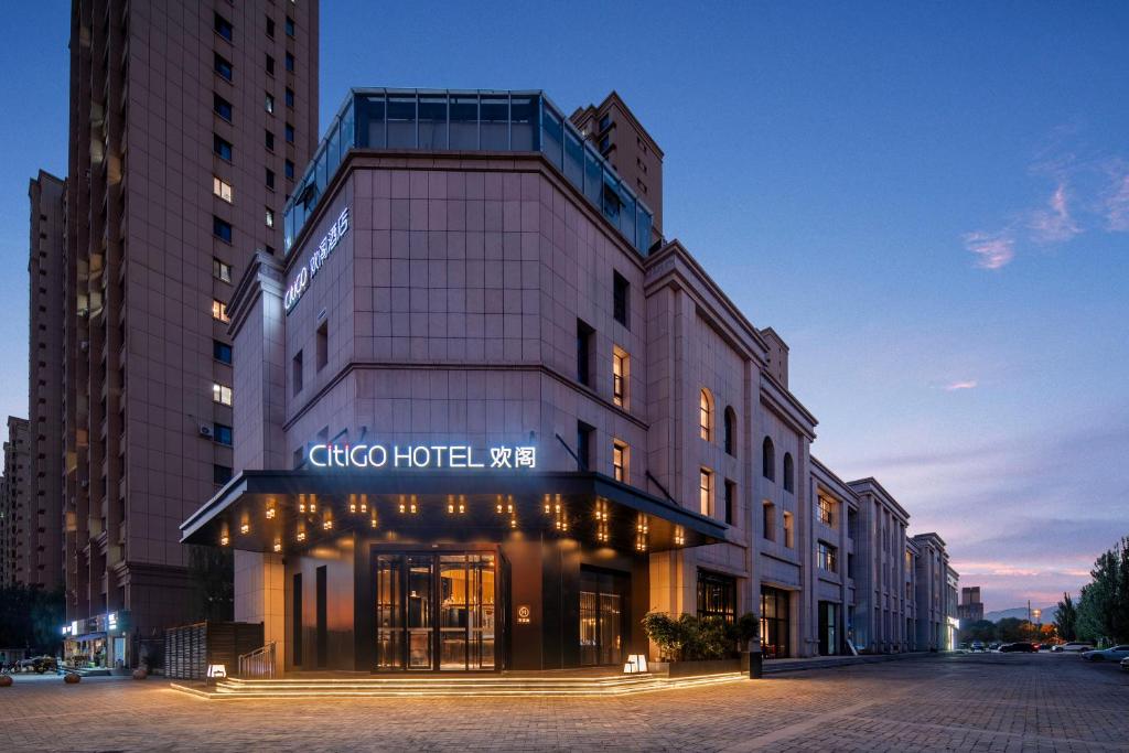 呼和浩特呼和浩特东站CiTiGO欢阁酒店的正面有标志的建筑物