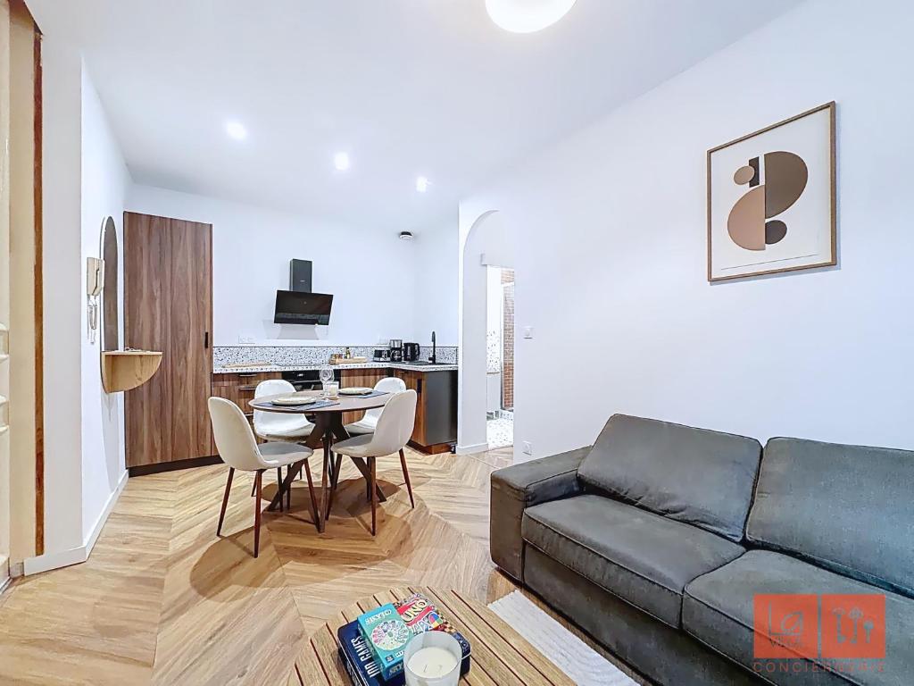 a living room with a couch and a table at Le Parvis - Vieille ville - proche plage et port in Boulogne-sur-Mer