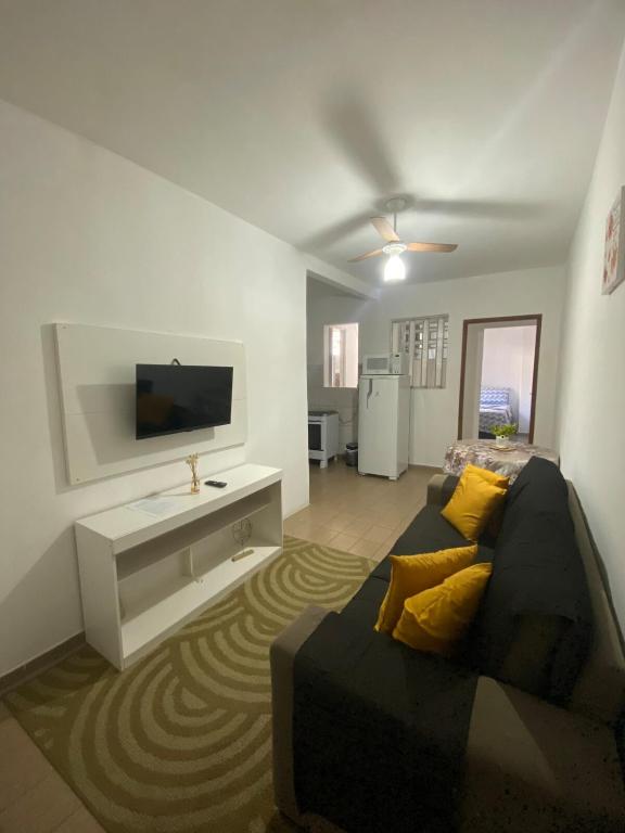 a living room with a couch and a flat screen tv at Ao lado do Hospital Calixto apartamento térreo in Itabuna