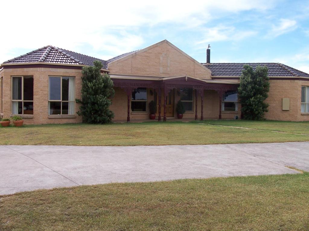 a brick house with a driveway in front of it at Roshnier Apartment in Warrnambool