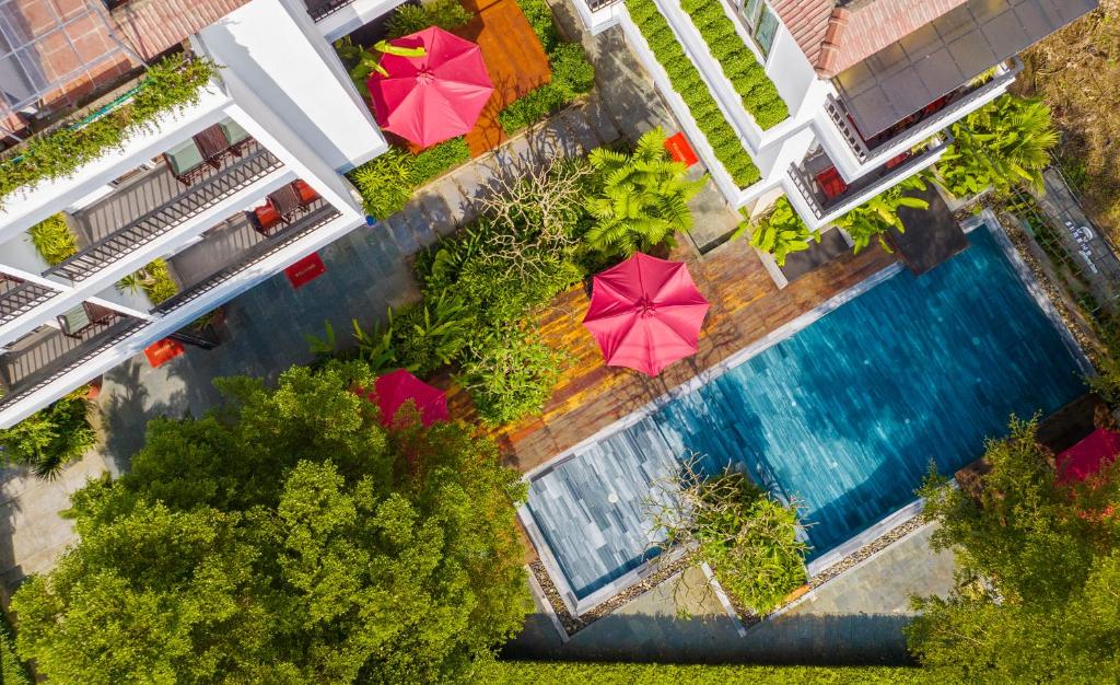 an overhead view of a swimming pool with umbrellas at Gia Huy Riverside Hotel Hoi An in Hoi An